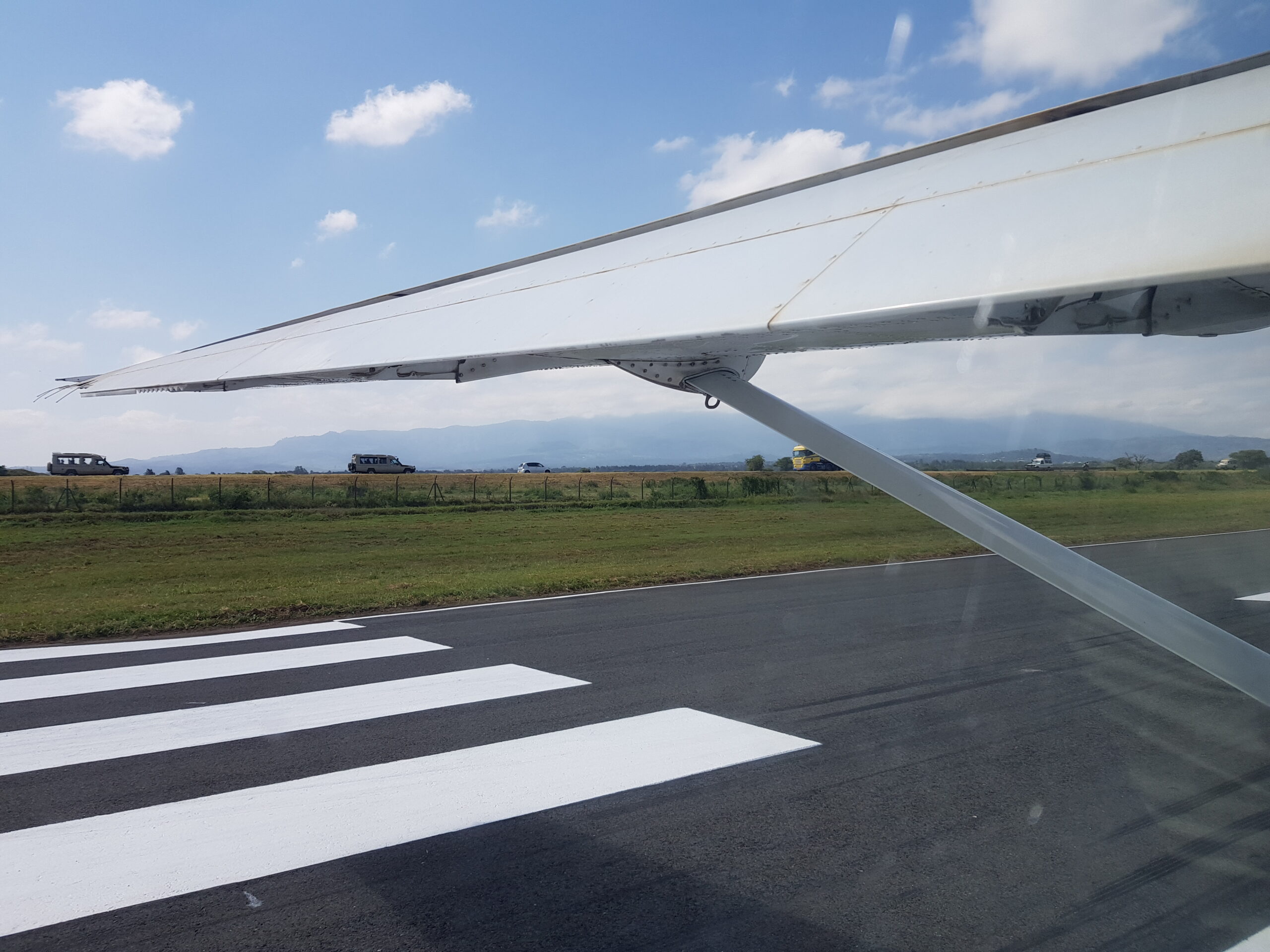 Photo of a plane wing with airstrip marketing before flying off